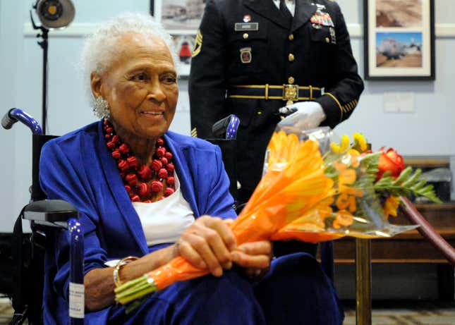 Romay Davis, 102, holds flowers after a ceremony honoring her service in World War II during a ceremony in Montgomery, Ala., on Tuesday, July 26, 2022. 