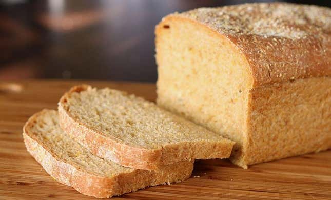 Loaf of Anadama bread with two slices on cutting board