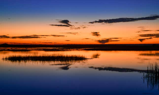 Morning glow in orange and blue shortly before sunrise on the Copahee Sound in Mount Pleasant, South Carolina.