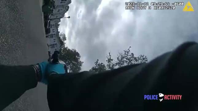 A photo of a police officer firing their gun at a squad car. 