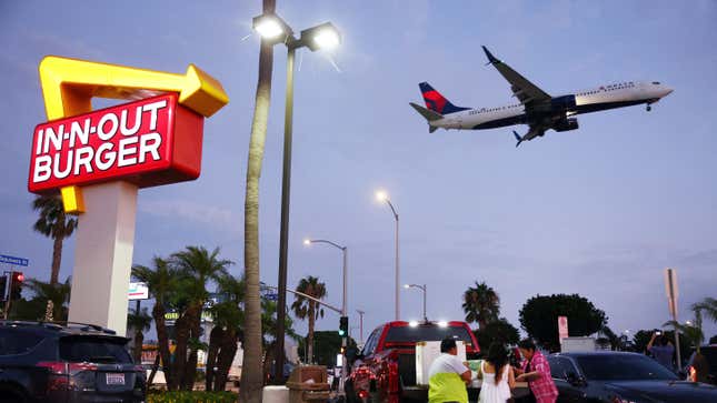 Plane flying over In-N-Out sign