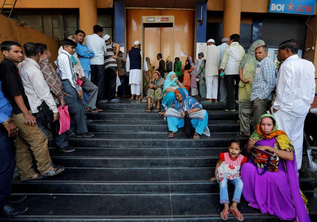 People wait for a bank to open to withdraw and deposit their money, after the scrapping of high denomination 500 and 1,000 Indian rupees currency notes.
