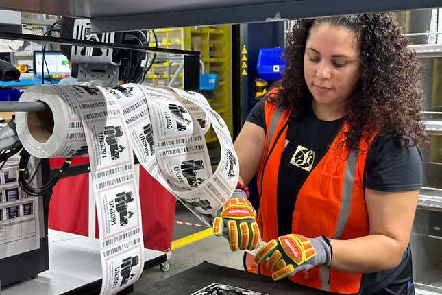 A worker handles labels at an Amazon same-day delivery shipping center in Woodland Park, N.J., on December 18, 2023. On Wednesday, the Labor Department reports on job openings and labor turnover for November. (AP Photo/Ted Shaffrey)