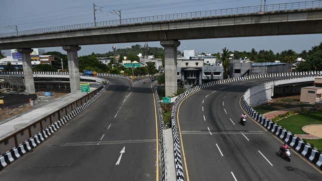 Motorists make their way through a partially deserted road after a complete lockdown was imposed by the state government  in Chennai on May 24, 2021.