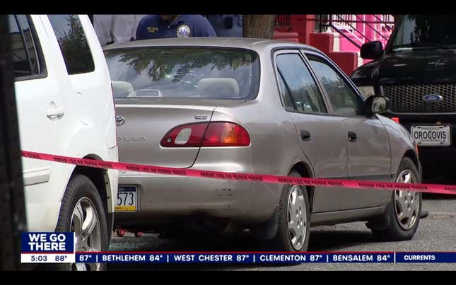 A gold Toyota Corolla surrounded by red police tape, parked facing the wrong direction for traffic 