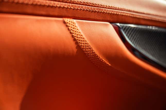 Interior detailing of an orange 2025 Aston Martin DBX707