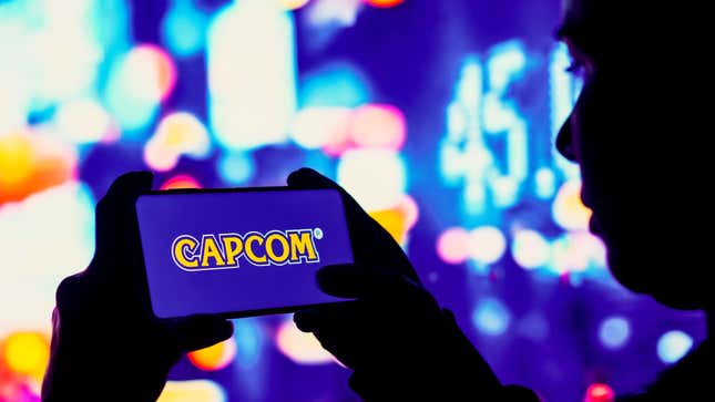 Quelqu’un tient un téléphone avec l’étiquette Capcom sur un fond violet affiché sur l’écran.