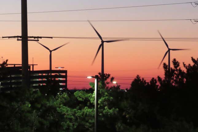 The sun sets behind spinning land-based wind turbines in Atlantic City, N.J. on Dec. 13, 2023. On Jan. 24, 2024, New Jersey utilities regulators approved two additional offshore wind farms, bringing the state&#39;s number to three. (AP Photo/Wayne Parry)