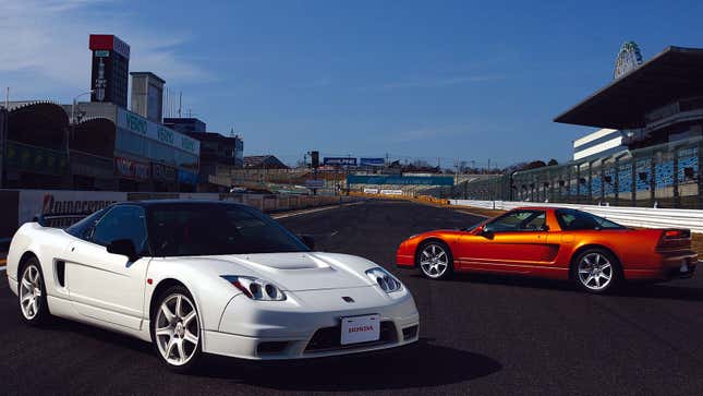 A photo of two Honda NSX supercars at a race track. 