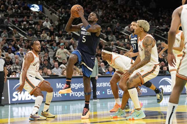 Nov 10, 2023; San Antonio, Texas, USA; Minnesota Timberwolves guard Anthony Edwards (5) drives to the basket between San Antonio Spurs forward Jeremy Sochan (10) and guard Tre Jones (33) during the second half at Frost Bank Center.