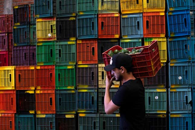 A worker carries a crate of avocados at a plant in Uruapan, Michoacan state, Mexico, Friday, Feb. 9, 2024. A lack of rain and warmer temperatures has resulted in fewer avocados being shipped from Mexico to the United States. (AP Photo/Armando Solis)