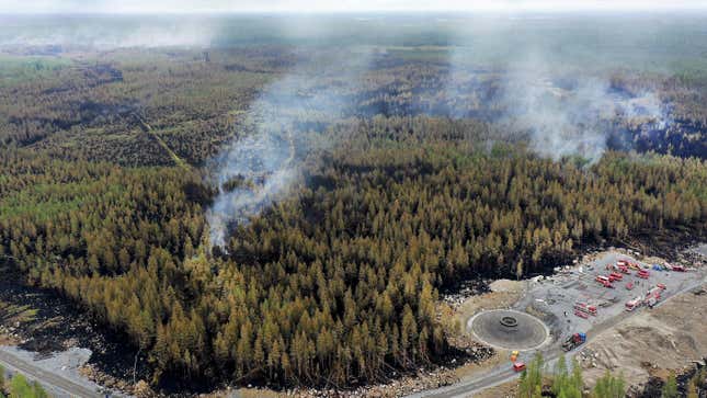 An aerial view shows smoke rising from the forest as firefighters and trucks work to extinguish a wildfire in Kalajoki, Northern Ostrobothnia region.