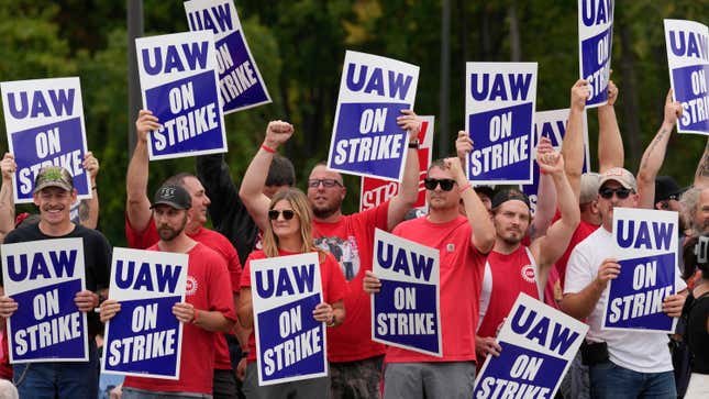 FILE - United Auto Workers members hold picket signs near a General Motors Assembly Plant in Delta Township, Mich., Sept. 29, 2023. As the auto workers strike approaches the one-month mark, more Americans sympathize with the striking workers than with the three big car companies that employ them. That&#39;s one of the findings in a new poll from The Associated Press-NORC Center for Public Affairs Research. (AP Photo/Paul Sancya)