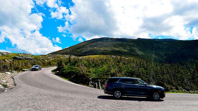 A photo of cars driving down a mountain pass. 