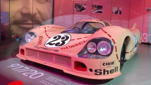 A photo of a pink Porsche 917 in a museum. 