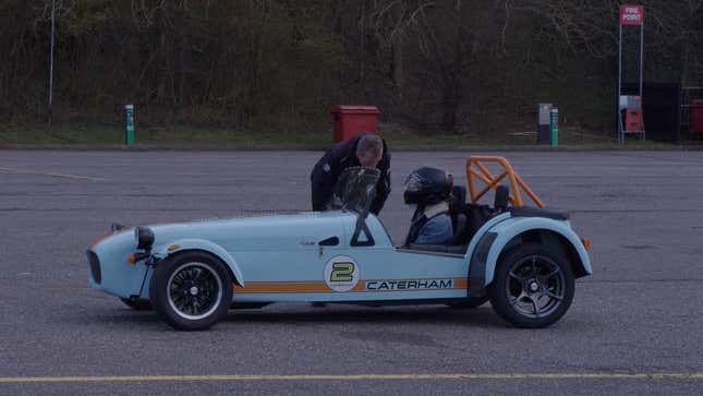 A photo of an instructor talking to the driver of a Caterham