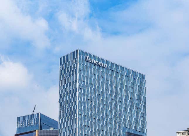 exterior view of tall office building against a blue sky with white letters in the top left corner that say "Tencent"