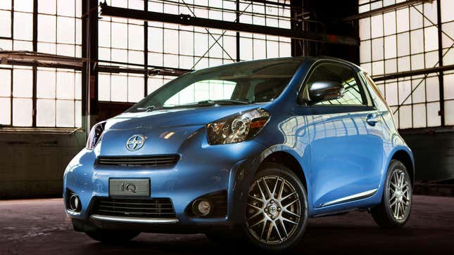 A photo of a blue Scion IQ in an old warehouse. 