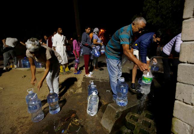 People queue to collect water from a spring in a Cape Town suburb last January