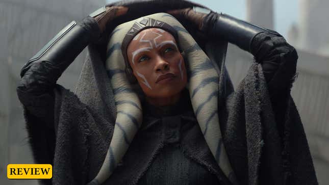 Rosario Dawson as Ahsoka Tano reveals her hood and looks upward. 