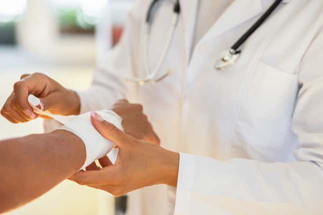 doctor wrapping a patient's arm in gauze