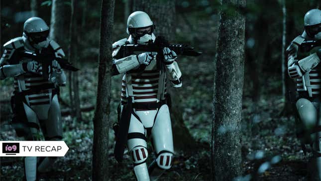 Three white-armored Commonwealth soldiers tread carefully through a darkened forest with their rifles ready.