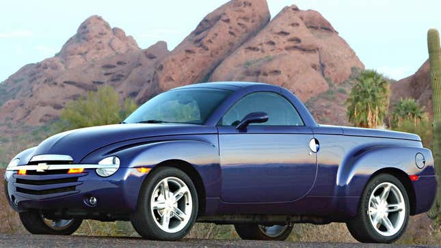 A purple Chevy SSR parked in front of some fake looking mountains