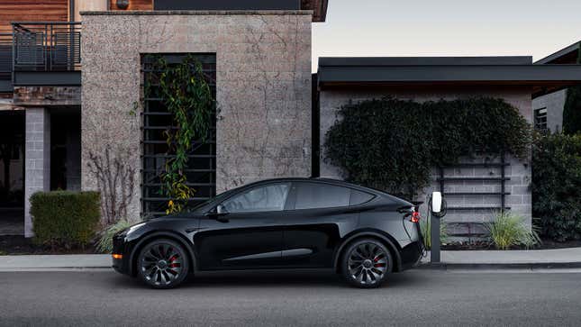 A photo of a Tesla Model Y charging at a house. 