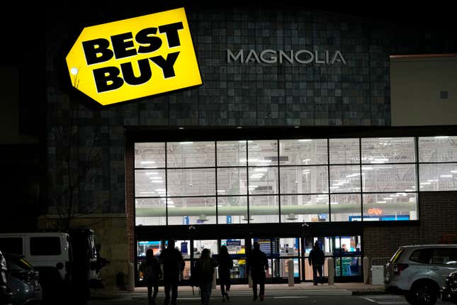 FILE - Shoppers are silhouetted as they walk toward a Best Buy store after doors opened at 5 a.m., Nov. 26, 2021, in Lone Tree, Colo. Best Buy is saying goodbye to movie-watching with physical discs. The consumer electronics retailer plans to phase out its DVD and Blu-ray sales by early 2024 — with physical movies set to be sold in-stores and online as they are today through the holidays. (AP Photo/David Zalubowski, file)