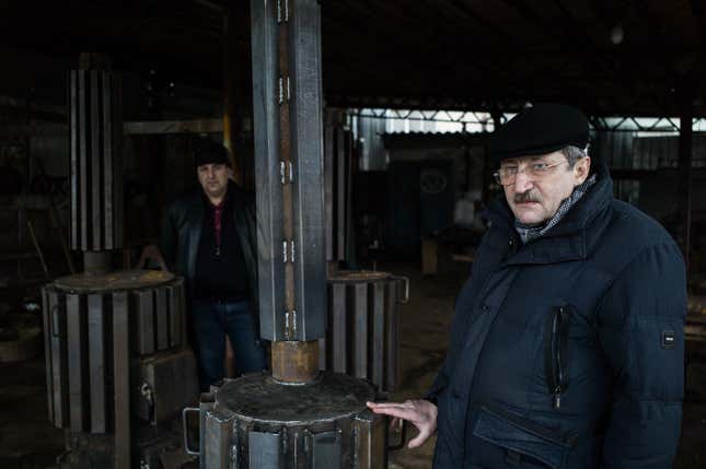Sasha (left) and Alik (right) at their workshop, showing off the “nitsakhon” (victory) stove.