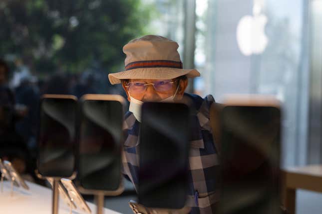 File - A man looks at the Apple&#39;s new iPhone 15 models on the first day of sales at an Apple Store in Los Angeles on Sept. 22, 2023. On Tuesday, the Commerce Department releases U.S. retail sales data for September. (AP Photo/Jae C. Hong, File)