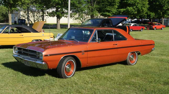 An orange 1968 Dodge Dart on a grass lawn.