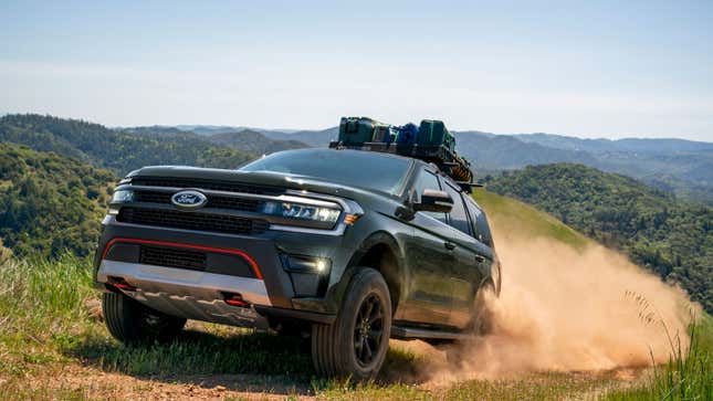 A photo of a black Ford SUV driving on dirt. 