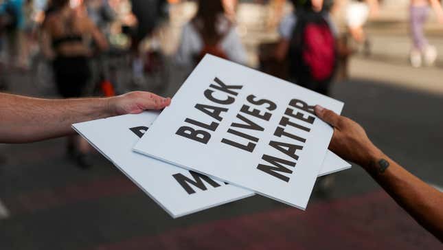 Protesters carry Black Lives Matter signs on a road during racial inequality protests in downtown Washington DC on June 23.