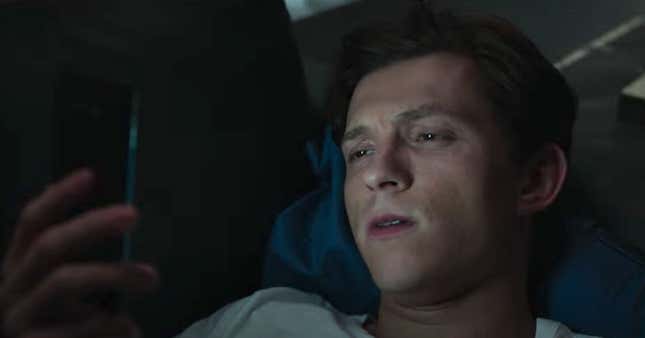 Tom Holland as Peter Parker in Spider-Man: No Way Home, staring at his phone. 