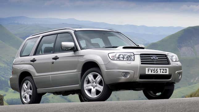 A silver 2008 forester turbo parked in front of mountains