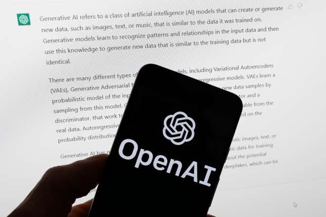 Logotipo de openai mostrado en un teléfono móvil frente a la pantalla de una computadora que muestra la respuesta de ChatGPT