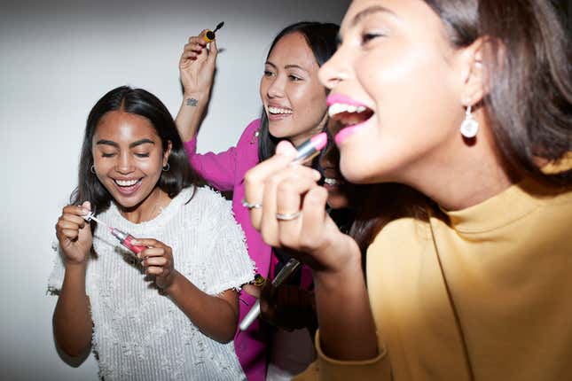 Eine Gruppe von Frauen, die gemeinsam Lippenstift auftragen