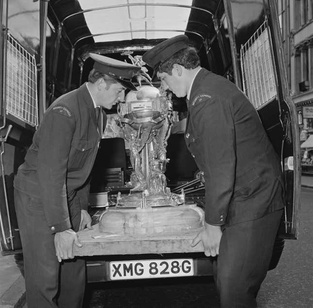 Two officers carrying the Hales Trophy, award for the fastest Atlantic crossing by a commercial vessel, UK, 6th August 1969.