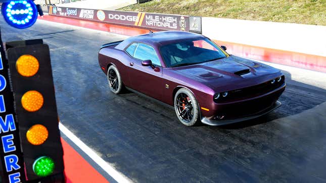 A purple Dodge Challenger muscle car at a drag strip 