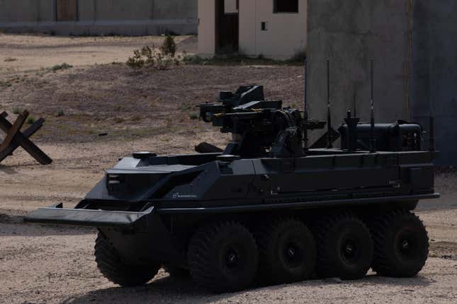 A British unmanned, eight-wheeled, all-terrain transport vehicle armed  with an autonomous weapon system by the U.K. Experimentation and Trails  Group provides support to dismounted Soldiers in an urban environment as  part of a human integration experiment at Fort Irwin, Calif, March 11,  2024.