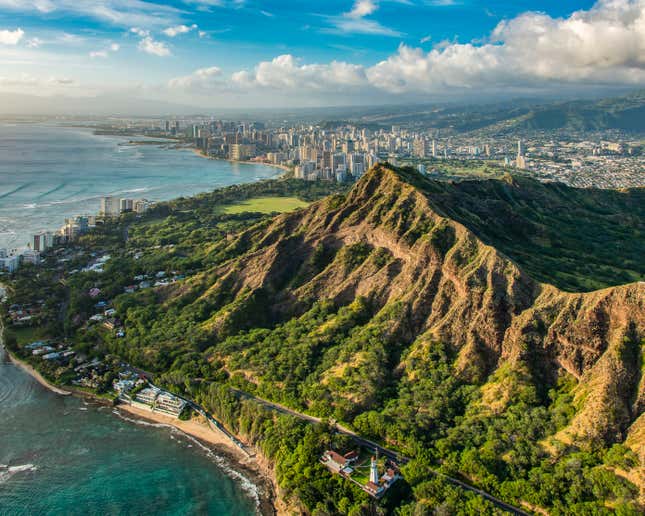 Aerial view of the Diamond Head Crater with Honolulu’s cityscape in the distance in Oahu, Hawaii.