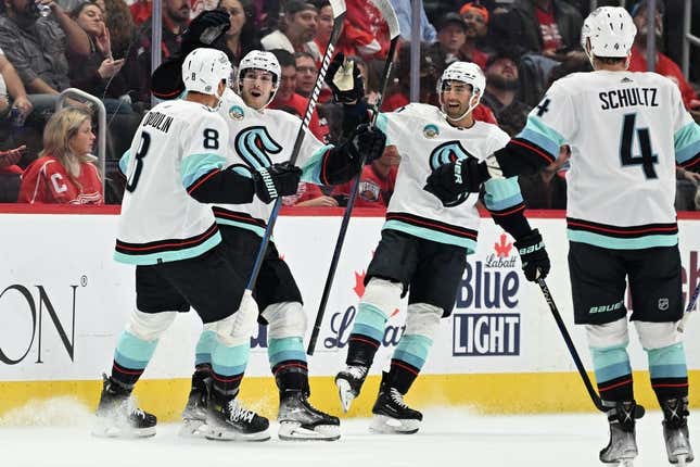 Oct 24, 2023; Detroit, Michigan, USA; Seattle Kraken defenseman Brian Dumoulin (8) celebrates with Seattle Kraken left wing Tye Kartye (52) (center left) right wing Jordan Eberle (7) (center right) and defenseman Justin Schultz (4) after the Kraken scored a goal against the Detroit Red Wings in the second period at Little Caesars Arena.