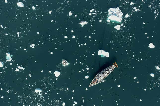 A scientific expedition sailing vessel Kamak is navigated amid fragments of melting icebergs in Scoresby Fjord, Greenland on August 16, 2023. The French National Centre for Scientific Research (CNRS) is undertaking an expedition to explore Greenland's isolated fjords, the planet's largest fjord system, which remains vastly understudied. The expedition, arranged by the volunteer-run French initiative Greenlandia, is dedicated to understanding the climate change's effects on Scoresby Fjord and its inhabitants.