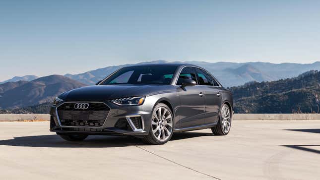 A gray Audi A4 parked in front of a mountain view