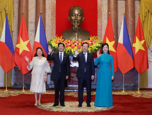 Philippine President Ferdinand Marcos Jr., second left, and Vietnamese President Vo Van Thuong and their wives wave to the media before a meeting in Hanoi, Vietnam, Tuesday, Jan. 30, 2024. Marcos Jr. is on a two-day visit to Hanoi. (Hoang Thong Nhat/VNA via AP)