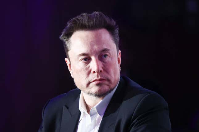 Elon Musk wearing a white button down and black suit jacket