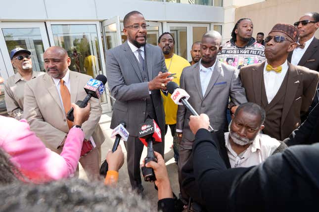 Civil lead counsel Malik Shabazz, center, speaks to reporters following the sentencing of the fourth former Rankin County law enforcement officer, while his client Michael Corey Jenkins, right, listens while outside the federal courthouse in Jackson, Miss., Wednesday, March 20, 2024. Christian Dedmon was sentenced for his part in the racist torture of Parker and Michael Corey Jenkins by a group of white officers who called themselves the “Goon Squad”