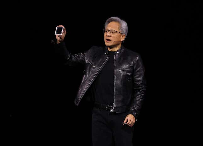 close up of Jensen Huang on stage holding up AI hardware