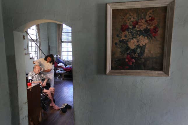 A home caregiver assists an elderly man.